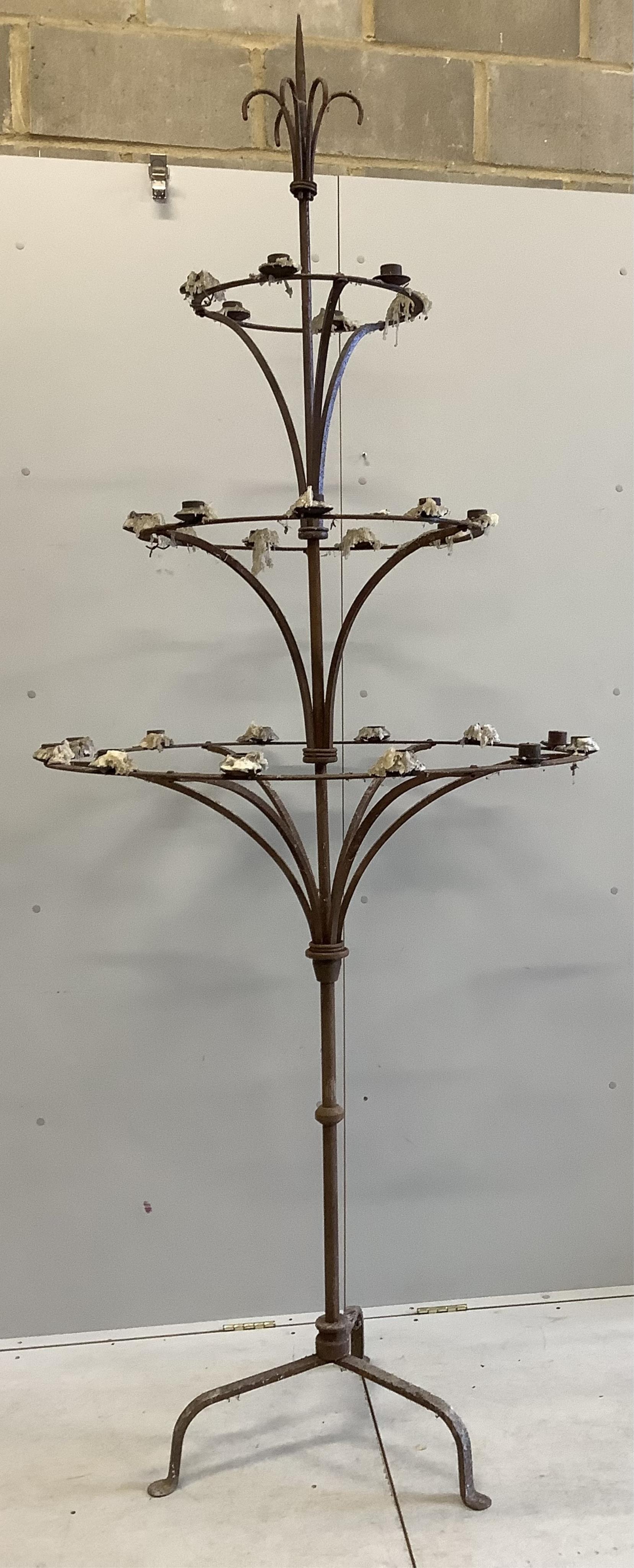 A pair of French wrought iron three tier candlestands, on tripod bases, diameter 95cm, height 254cm. Condition - fair although rusted